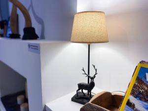 una lámpara en una mesa con un ciervo. en ÜNik - Rústico & Moderno En Arinsal - ESQUÍ, en Mas de Ribafeta