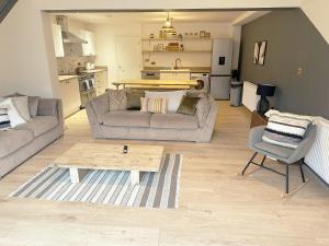 Sala de estar con 2 sofás y mesa de centro en Cotswold's Large 4 bed house-Sleeps 10-Free Parking-Wifi 