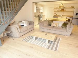 a living room with two couches and a table at Cotswolds-Stroud-Comfy 4 bed house-Sleeps 10-Free Parking-Wifi in Ebley