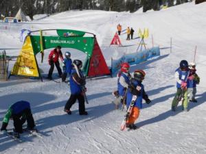 un groupe d'enfants debout dans la neige avec des skis dans l'établissement Zimmer für Backpaking - Das gemütliche Haus des Grossvaters - Bergheimat - Ganz einfach - ganz unkompliziert - ganz relaxd, à Linthal