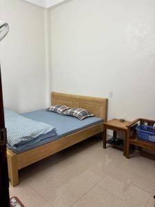 Schlafzimmer mit einem Bett und einem Beistelltisch in der Unterkunft Nhà nghỉ Ngọc Khánh in Dồng Văn