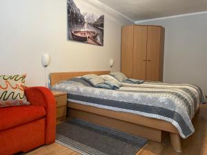 ein Schlafzimmer mit einem Bett und einem roten Stuhl in der Unterkunft Apartmán Stráne in Martin