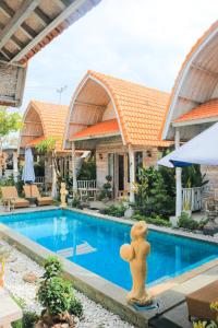 a pool with a teddy bear statue in front of a house at The Box Paradise Cottage in Nusa Penida