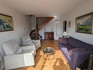 a living room with two couches and a table at Les Sables d'Or - accès direct plage, vue mer, terrasses, parking in Houlgate