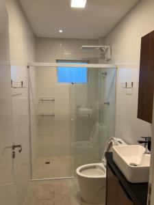a bathroom with a shower and a toilet and a sink at Apartamento São Francisco - Praia do Gravatá - Beto Carrero World in Navegantes +21 photos