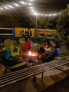 grupa ludzi siedzących w nocy przy ogniu w obiekcie KIRTIPUR COMFORT HOMESTAY with breakfast & dinner w mieście Kirtipur