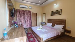 een slaapkamer met een bed met een boog erop bij NH16 Farm Stay And Restaurant in Chāndpur