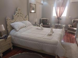 a bedroom with a large white bed with stuffed animals on it at المهندسين شقه سوبر لوكس - محى الدين ابو العز in Cairo