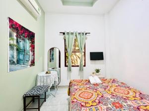 1 dormitorio con cama, mesa y espejo en A.N Homestay en Phan Thiet