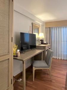 a desk with a television and a chair in a room at Aonang All Seasons Beach Resort in Ao Nang Beach