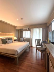 una camera con un grande letto e una sedia di Aonang All Seasons Beach Resort ad Aonang Beach