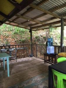 porche con terraza de madera con mesa y sillas en Camp Talusi Hills Overlooking, en El Nido