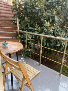 Amli Apartament في تيرانا: وجود كرسي خشبي بجانب طاولة وسياج
