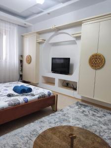 a bedroom with a bed and a flat screen tv at X,ata in Almaty