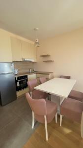 - une cuisine avec une table blanche et des chaises dans l'établissement Lux Apartman Atlantis, à Zlatibor 5 autres photos