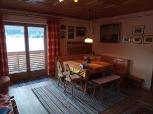 ein Esszimmer mit einem Holztisch und Stühlen in der Unterkunft Dopplerhof's Staufenhaus in Piding
