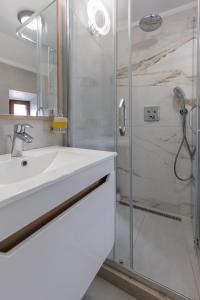 a bathroom with a sink and a shower at Old Town South Gate Apartment in Kotor