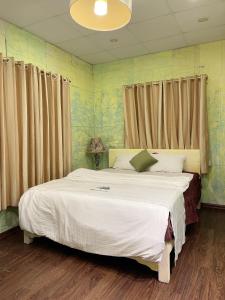 a bedroom with a large white bed with curtains at Lyna House in Hanoi