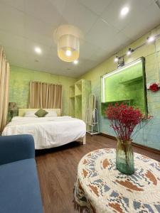 a bedroom with a bed and a vase of flowers on a table at Lyna House in Hanoi