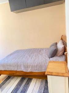 a bedroom with a bed with a wooden table at Cosy 2 room 55m2 Centric 10min to Old Town AC in Rīga