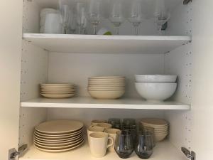 a cabinet filled with plates and bowls and glasses at Cosy 2 room 55m2 Centric 10min to Old Town AC in Rīga