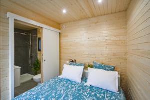a room with a bed and a bathroom with a shower at ღ L'Oasis Maluti - Chalet aux portes de Beauval in Châtillon-sur-Cher