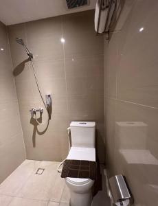 een badkamer met een toilet en een telefoon aan de muur bij Deli Hotel in Medan