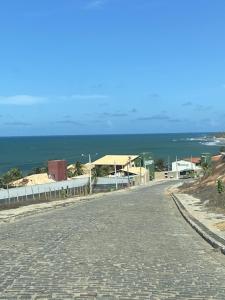 una calle vacía con el océano en el fondo en Villasollagoinha, en Paraipaba