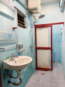 a bathroom with a sink and a red door at Lyna House in Hanoi