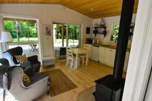 cocina y sala de estar con estufa de leña en Owl Cabin - Cozy Forest Retreat nearby Lake en East Kemptville