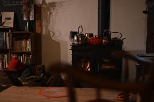 a living room with a stove with pots and pans at Guesthouse Soranoie in Gero