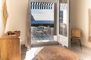 a room with a door to a balcony with a table at ECHO DES FLOTS vue mer in Cassis
