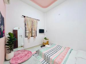 Cette chambre blanche comprend un lit et un miroir. dans l'établissement A.N Homestay, à Phan Thiết