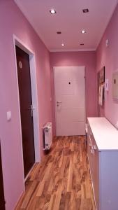 a kitchen with pink walls and a wooden floor at Rentcenter79_2 in Sankt Michael in Obersteiermark