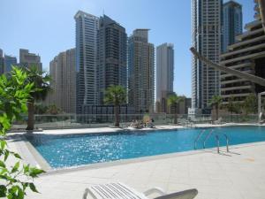 a large swimming pool in a city with tall buildings at Vacay Lettings -2 Bed Iris Blue Dubai Marina in Dubai