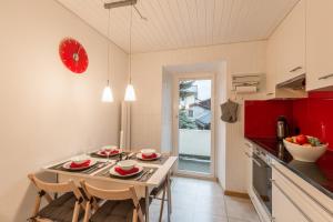 シュクオルにあるChasa Silvrettaのキッチン(テーブル付)、壁に赤い時計