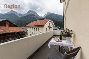 a balcony with a table and a view of mountains at Chasa Silvretta in Scuol