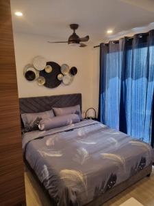 a bedroom with a bed with blue curtains and a fan at HarbourBay Residence. Batam. Studio. 1min to Ferry in Jodoh
