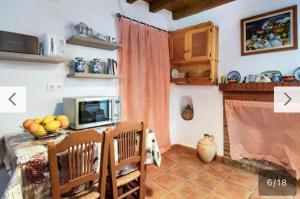 Guájar FondónにあるCasa La Estrellaのキッチン(テーブル付)、テレビが備わります。