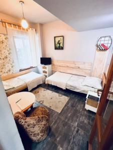 ドゥシュニキ・ズドルイにあるNoclegi u Ewyのリビングルーム(ベッド2台、椅子付)