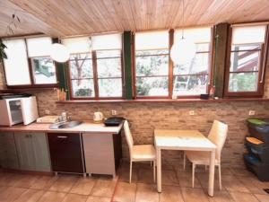 a kitchen with a table and chairs and windows at Noclegi u Ewy in Duszniki Zdrój