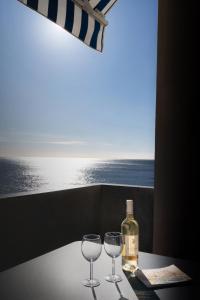 a table with two glasses and a bottle of wine at ECHO DES FLOTS vue mer in Cassis +22 photos