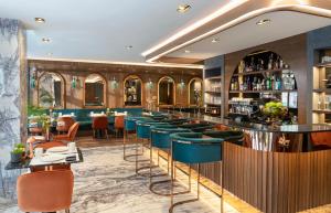 a restaurant with a bar with blue stools at Nex Hotel & Spa Istanbul in Istanbul