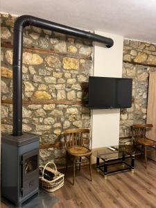 a living room with a stone wall with a stove at Vila Ndrio in Pogradec