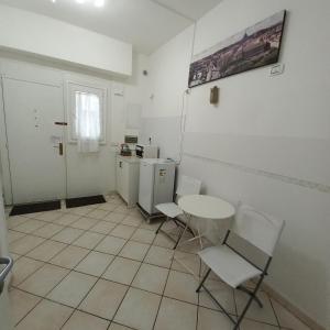 ローマにあるLa Casetta di Paolaのテーブルと椅子、キッチンが備わる客室です。