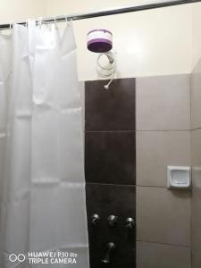 una ducha con cabezal de ducha púrpura en la pared en AMOR LAKEBREEZE 3, en Kisumu