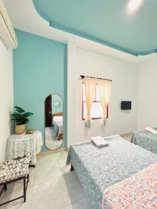 - une chambre avec 2 lits et un miroir dans l'établissement A.N Homestay, à Phan Thiết