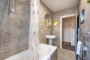 a bathroom with a bath tub and a sink at *Rb12s* For your most relaxed & Cosy stay + Free Parking + Free Fast WiFi * in Headingley