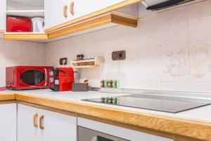una cocina con microondas rojo en una encimera en Holidays. Europa 8 personas. 3 dormitorios. C7, en Sierra Nevada