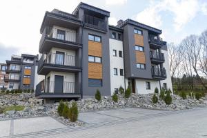 a large apartment building with rocks in front of it at VacationClub – Spokojna 24I Apartament 1 in Wisła